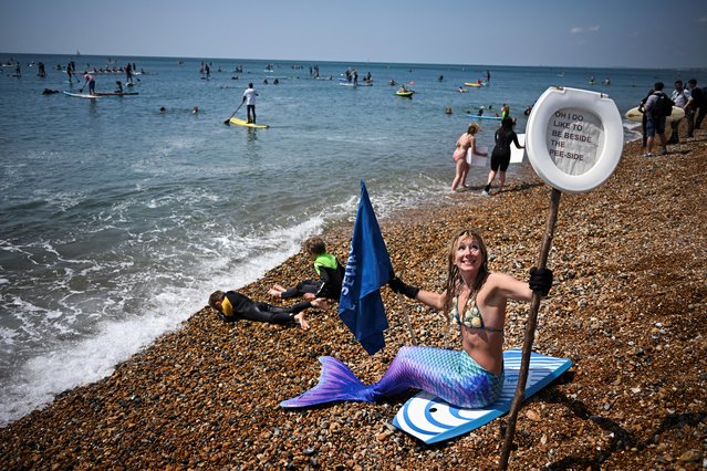 Surfers take part in a mass protest, organised by Ocean Charity Surfers, to demonstrate against the continued dumping of untreated sewage by water companies off the coast of Brighton, Britain on May 20, 2023. (Photo by Dylan Martinez/Reuters)