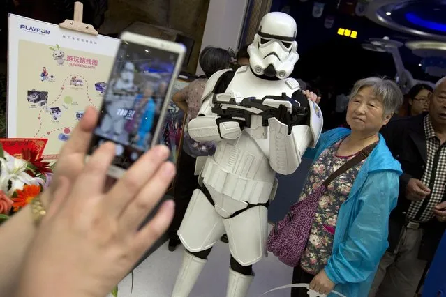A Chinese woman poses for a smartphone photo with a worker dressed in a storm trooper costume at the Wanda Mall at the Wanda Cultural Tourism City in Nanchang in southeastern China's Jiangxi province, Saturday, May 28, 2016. China's largest private property developer, the Wanda Group, opened an entertainment complex on Saturday that it's positioning as a distinctly homegrown rival to Disney and its $5.5 billion Shanghai theme park opening next month. (Photo by Mark Schiefelbein/AP Photo)