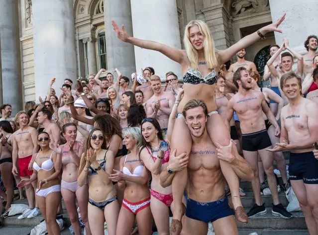 A flashing flashmob paraded around central London in their underwear in a protest over bank charges, on June 13, 2014. The semi-naked gang stripped down to their bras and briefs – giving morning commuters an eyeful. The scantily clad protesters stunned passengers at Liverpool Street Station and were also spotted in Angel, Farringdon and Kings Cross Square. More than 100 daring campaigners turned out for the event – which luckily coincided with the warmest day of the year so far. (Photo by Jeff Moore)