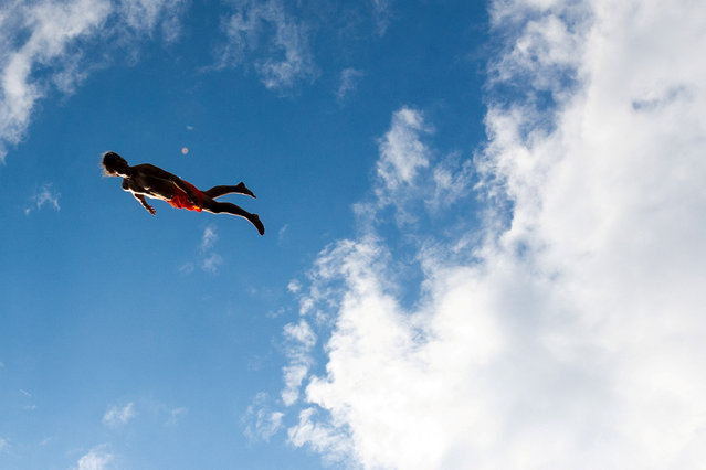 A competitor jumps into the water during a cliff diving competition near the Central Bohemian village of Hrimezdice, Czech Republic on August 3, 2024. (Photo by Eva Korinkova/Reuters)