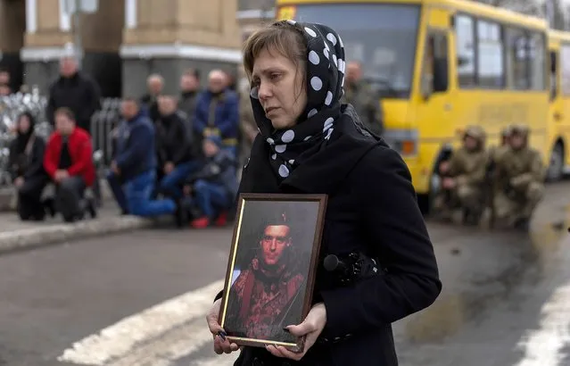 Myroslava Mamchuk holds a picture of her godson Ukrainian soldier Dmitry Zhelisko during his funeral at the Church of St. Volodymyr on April 03, 2022 in Chervonohrad, Ukraine. Zhelisko died fighting the Russian army near the town of Kharkiv. More than five weeks since the Russian invasion began, Ukraine's military losses are still unclear, with the last official account coming on March 12, when the government acknowledged that 1,300 Ukrainian soldiers had been killed. (Photo by Joe Raedle/Getty Images)