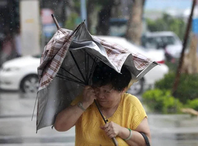 A woman holds her umbrella while walking against strong winds as Typhoon Soudelor hits Taipei, Taiwan, August 8, 2015. (Photo by Pichi Chuang/Reuters)