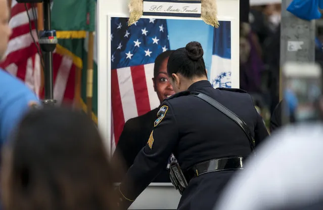 A portrait of slain New York police officer Miosotis Familia is placed on a podium before a tribute in her honor at the New York police department's 46th Precinct in the Bronx borough of New York, Saturday, July 8, 2017. Familia was shot to death early Wednesday, ambushed inside her command post by an ex-convict, who was later killed after pulling a gun on police. (Photo by Craig Ruttle/AP Photo)