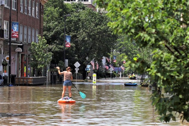 A person rows a paddle board in a flooded area in Montpelier, Vermont, U.S. July 11, 2023. (Photo by Brian Snyder/Reuters)