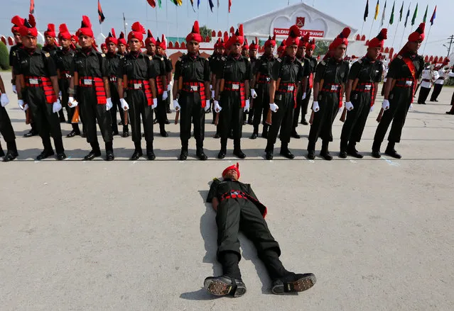 An Indian army recruit faints during a passing out parade at a garrison in Rangreth on the outskirts of Srinagar, July 15, 2017. (Photo by Danish Ismail/Reuters)
