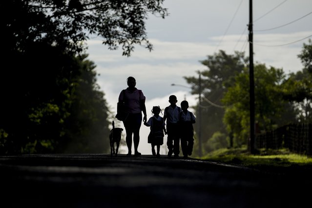 A woman walks with her children through the street in Piriati, Panama, September 25, 2024. (Photo by Matias Delacroix/AP Photo)