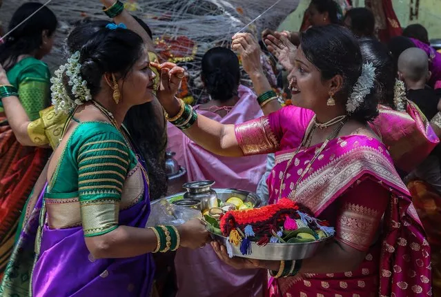 Hindu married women perform rituals around a banyan tree during the Vat Savitri (also called Vat Purnima) festival in Bhayander, outskirts of Mumbai, India, 14 June 2022. Hindu married women celebrate the day by fasting and worshiping the tree, wishing their husbands a long and healthy life. (Photo by Divyakant Solanki/EPA/EFE)