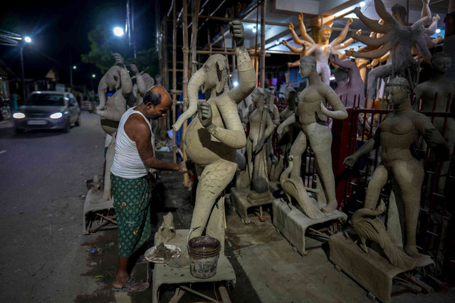 An Indian artisan makes Durga idol near a road outside his workshop ahead of the Hindu Durga festival in Guwahati, India, Wednesday, October 2, 2024. (Photo by Anupam Nath/AP Photo)