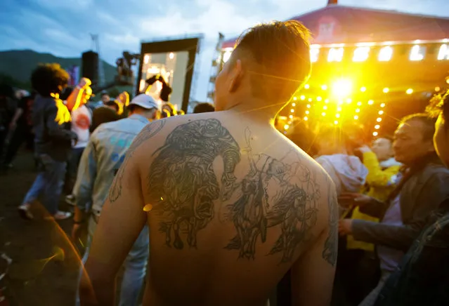 A reveller with a tattoo in his back attends the Play Time 2016 music festival on the outskirts of Ulaanbaatar, Mongolia, June 26, 2016. (Photo by Jason Lee/Reuters)