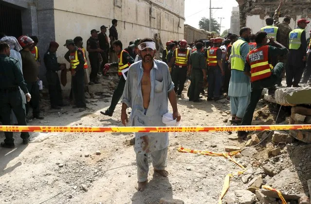 An injured man walks away as rescue workers search after a blast near the home of the home minister of Punjab province, Shuja Khanzada, in Attock, Pakistan, August 16, 2015. The bomb killed Khanzada and at least eight others when it destroyed the minister's home on Sunday in Prime Minister Nawaz Sharif's political heartland, rescue officials said. (Photo by Khuram Parvez/Reuters)