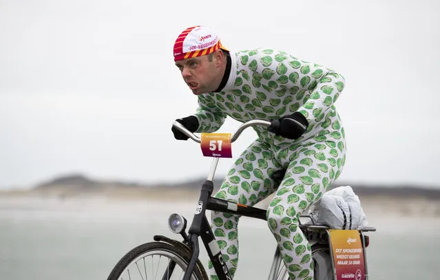 A competitor wearing a onesie with Brussels sprouts battles gale force winds during the Dutch Headwind Cycling Championships on the storm barrier Oosterscheldekering near Neeltje Jans, south-western Netherlands, Sunday, February 9, 2020. (Photo by Peter Dejong/AP Photo)