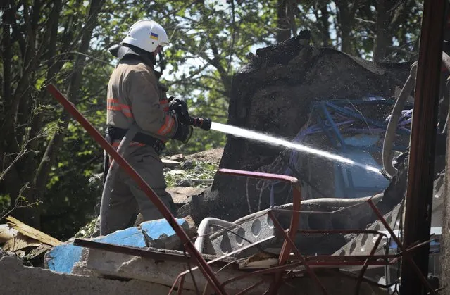 Ukrainian State Emergency Service firefighter works to extinguish a fire at at damaged residential building in the town of Serhiivka, located about 50 kilometers (31 miles) southwest of Odesa, Ukraine, Friday, July 1, 2022. Russian missile attacks on residential areas in a coastal town near the Ukrainian port city of Odesa early Friday killed at least 19 people, authorities reported, a day after Russian forces withdrew from a strategic Black Sea island. (Photo by Nina Lyashonok/AP Photo)