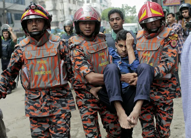 Bangladesh fire brigade personnel rush an injured man to hospital after a blast, as Bangladeshi policemen try to flush out suspected Islamist radicals who have holed up in a building in Dhaka, Bangladesh, Tuesday, August 15, 2017. (Photo by AP Photo)