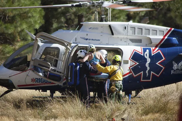 In this Wednesday, September 27, 2017, photo provided by Dakota Snider, photographer and Yosemite resident, a woman is carried into a helicopter after being rescued off El Capitan following a major rock fall in Yosemite National Park, Calif. All areas in California's Yosemite Valley are open Thursday, a day after the fatal rock fall. (Photo by Dakota Snider via AP Photo)