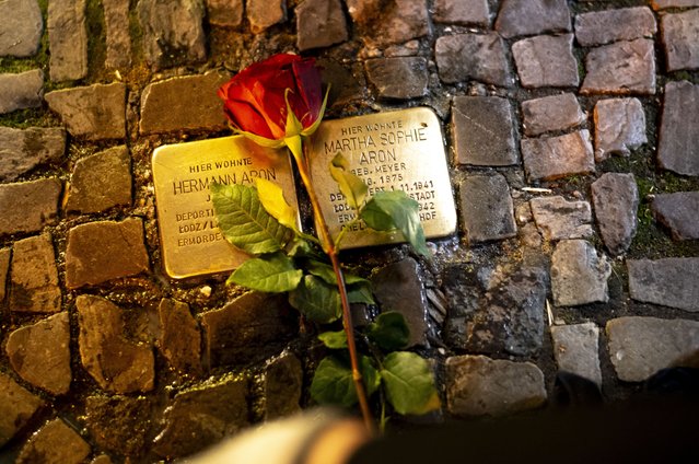 A rose is placed near a fresh polished so-called 'Stolpersteine' or 'stumbling stones' commemorating people, most of them Jews, deported and killed by the Nazis, at the eve of the 85th anniversary of the Nazis' anti-Jewish pogrom in 1938, in Berlin, Germany, Wednesday, November 8, 2023. The stones are among thousands set into sidewalks in front of houses in Germany and other European countries where victims of the Nazis lived or worked before they were deported and killed. The inscriptions include the names of the victims, the dates of their birth and of their deportation and murder. The stones are cleaned by residents on and around the Nov. 9 anniversary to commemorate the victims of Nazi Germany. (Photo by Markus Schreiber/AP Photo)