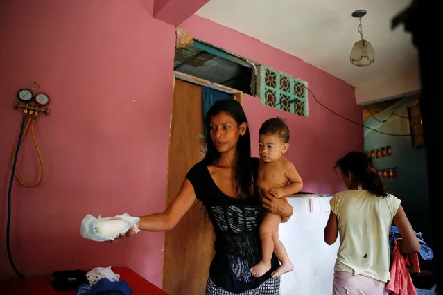 Geraldine Rocca, 29, carries her son Jeremy, ahead of her sterilization surgery in Caracas, Venezuela July 20, 2016. (Photo by Carlos Garcia Rawlins/Reuters)