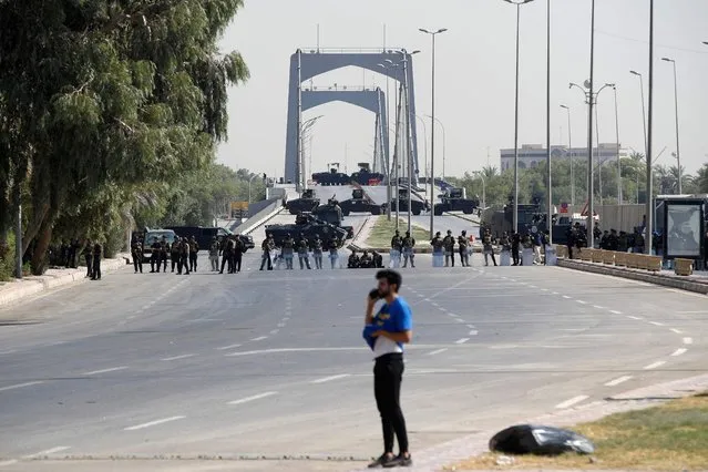 Iraqi police are pictured blocking the entrance into the capital Baghdad's Green Zone, on August 29, 2022. Dozens of angry supporters of the powerful cleric stormed the Republican Palace, a ceremonial building in the fortified Green Zone, a security source said, shortly after Sadr said he was quitting politics. The army has announced a  Baghdad-wide curfew to start from 3:30 pm (1230 GMT). (Photo by Ahmad Al-rubaye/AFP Photo)