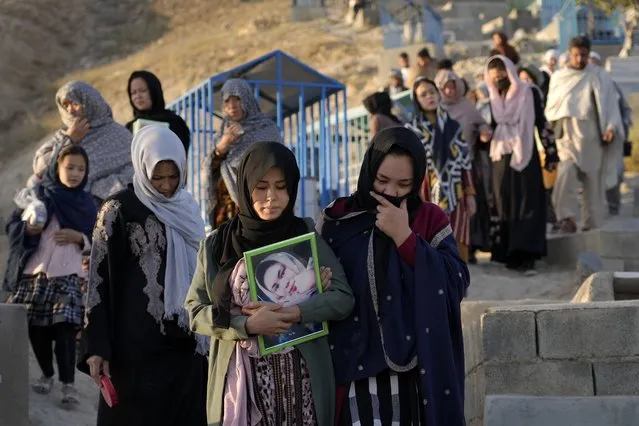 The family of 20-year-old Vahida Heydari, who was a victim of a suicide bombing on a Hazara education center, goes to her grave for a mourning ceremony, in Kabul, Afghanistan, Sunday, October 2, 2022. Last week’s suicide bombing at the Kabul education center killed as many as 52 people, more than double the death toll acknowledged by Taliban officials, according to a tally compiled by The Associated Press on Monday. (Photo by Ebrahim Noroozi/AP Photo)