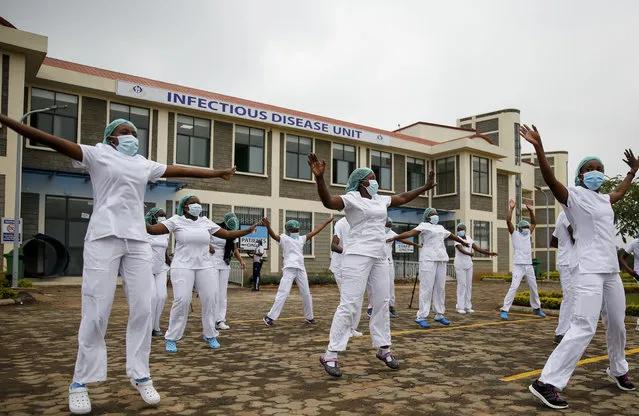 Nurses who take care of coronavirus patients at the infectious disease unit take part in a Zumba dance-fitness class put on to help them deal with the stress and difficult work, in the car park outside of the Kenyatta University Teaching, Referral and Research Hospital in Nairobi, Kenya Sunday, May 17, 2020. (Photo by Brian Inganga/AP Photo)