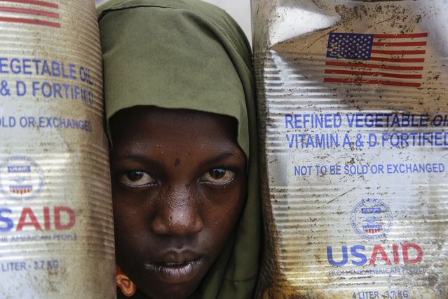 A Somali internally-displaced person (IDP) child looks out from her family's makeshift home in Maslah camp on the outskirts of Mogadishu, Somalia Wednesday, February 5, 2025. (Photo by Farah Abdi Warsameh/AP Photo)
