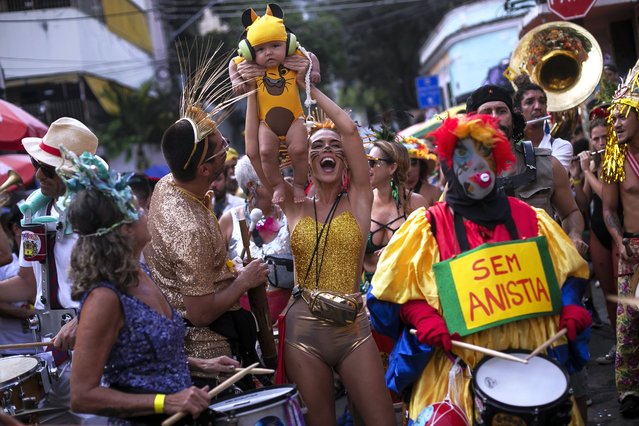 A woman holds up her son dressed as Simba from the Lion King, during the “Ceu na Terra” or Heaven on Earth pre-Carnival street party, in Rio de Janeiro, Brazil, Saturday, February 3, 2024. (Photo by Bruna Prado/AP Photo)