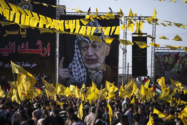 Palestinians chant slogans and wave yellow Fatah movement flags during a rally marking the 18th anniversary of the death of Fatah founder and Palestinian Authority leader Yasser Arafat in Gaza City, Thursday, November 10, 2022. (Photo by Fatima Shbair/AP Photo)