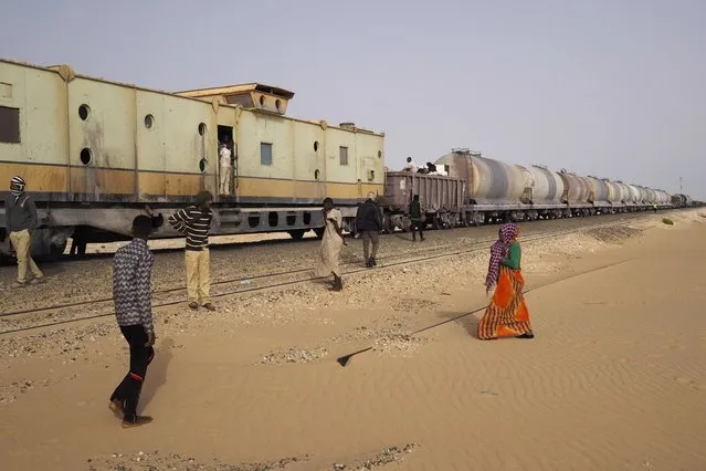 Passengers take a break while travelling on a SNIM train carrying iron ore and mine workers across the desert outside Nouadhibou June 25, 2014. (Photo by Joe Penney/Reuters)