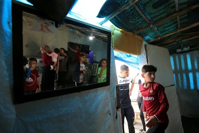 Yazidi displaced family of Nayef al-Hamo is reflected in the mirror as they prepare to leave their home in Sharya town and head back to Sinjar following the outbreak of the coronavirus disease (COVID-19) and economic crisis, near Dohuk, Iraq on July 3, 2020. (Photo by Ari Jalal/Reuters)