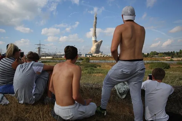 Locals watch as Grain Power Chimney comes down on September 7, 2016 in Isle of Grain, England. The 244m (801ft) chimney of Grain Power Station, a former oil-fired power station and the second tallest chimney in the UK was demolished by experts Brown and Mason at 11 am. (Photo by Dan Kitwood/Getty Images)
