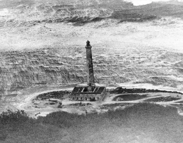 Wind and torrents of rain from hurricane Flora are pictured lashing this lighthouse on Buba's northeast coast as Associated Press staff photographer Jim Kerlin flew over a portion of the island on a flight to hurricane stricken Haiti.  Huge waves at the top of the photo sweep toward the light house at an unknown position on the Cuban coast shown October 9, 1963. (Photo by Jim Kerlin/AP Photo)