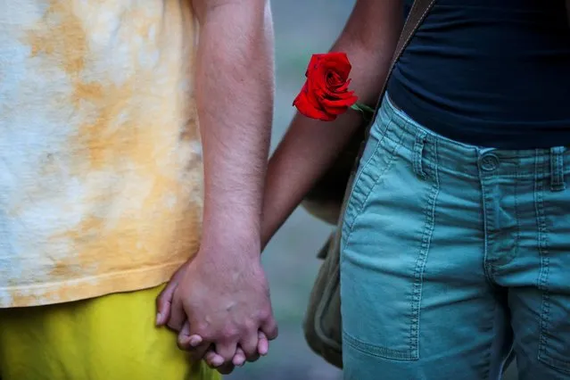 Demonstrators, one with a rose, hold hands in a rally against racial inequality and to call for justice a week after Black man Jacob Blake was shot several times by police in Kenosha, in Boston, Massachusetts, U.S., August 30, 2020. (Photo by Brian Snyder/Reuters)