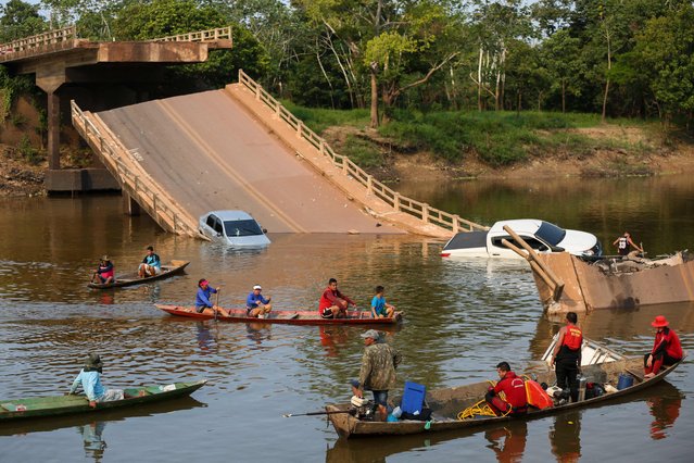 Locals and rescuers search for people who plunged into the Curuca river after a bridge collapsed in the municipality Careiro Da Varzea,  Amazonas state, Brazil, on 28 September 2022. The collapse of a bridge over the Curuçá River in the state of Amazonas caused the death of three people and injuries to 14, the Amazonas Fire Department said. (Photo by Michael Dantas/AFP Photo)