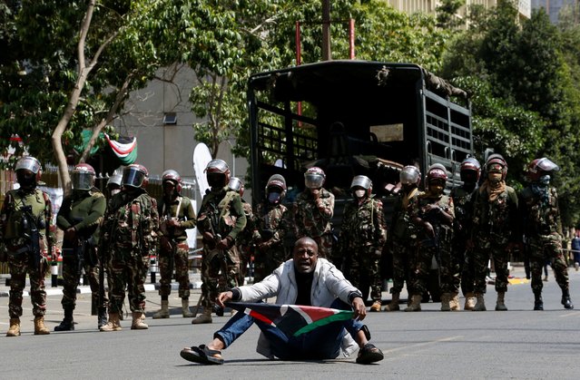 A protestor sits infront of riot police officers during a demonstration against the death of a blogger in police custody last week, in downtown Nairobi, Kenya on June 12, 2025. (Photo by Thomas Mukoya/Reuters)