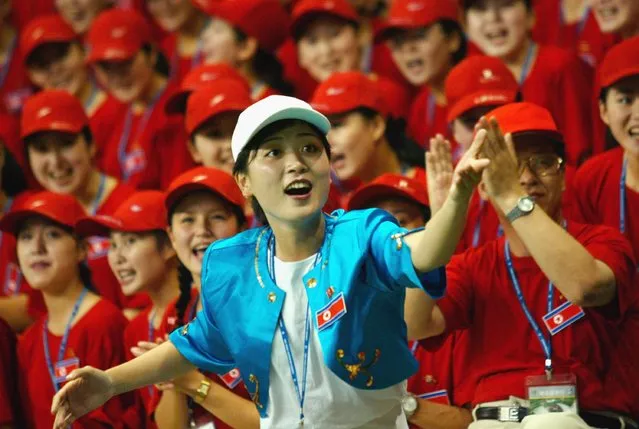 North Korean spectators cheer during a volleyball match between North Korea and Denmark at the World Student Games August 21, 2003 in Daegu, South Korea. North Korea and South Korea have agreed, in principle, to field a unified team for next years Olympic Games in Athens, Greece. (Photo by Chung Sung-Jun/Getty Images)