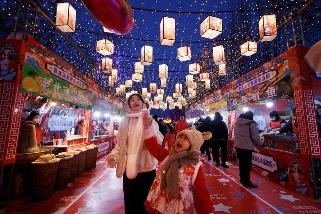 People walk through a decorated food court that is part of a Spring Festival light installation ahead of Chinese Lunar New Year in Qinglonghu Park in Beijing, China on January 21, 2023. (Photo by Thomas Peter/Reuters)