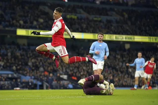 Manchester City's goalkeeper Stefan Ortega, bottom, saves on Arsenal's Gabriel Martinelli during the English FA Cup 4th round soccer match between Manchester City and Arsenal at the Etihad Stadium in Manchester, England, Friday, January 27, 2023. (Photo by Dave Thompson/AP Photo)