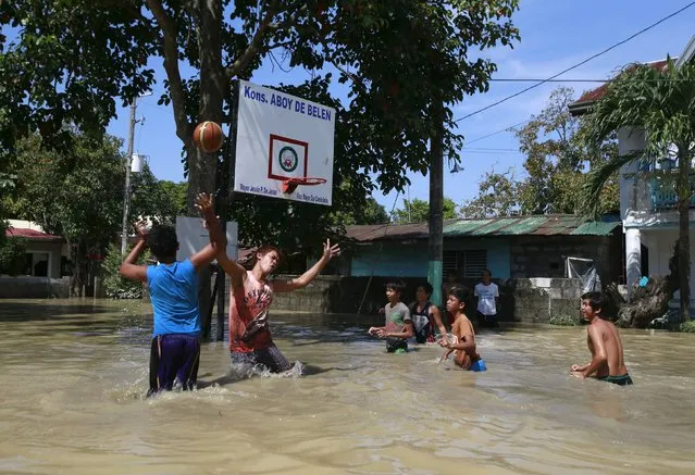 Residents play basketball while wading across floodwaters a week after typhoon Koppu battered Calumpit town, Bulacan province, north of Manila October 24, 2015. (Photo by Romeo Ranoco/Reuters)