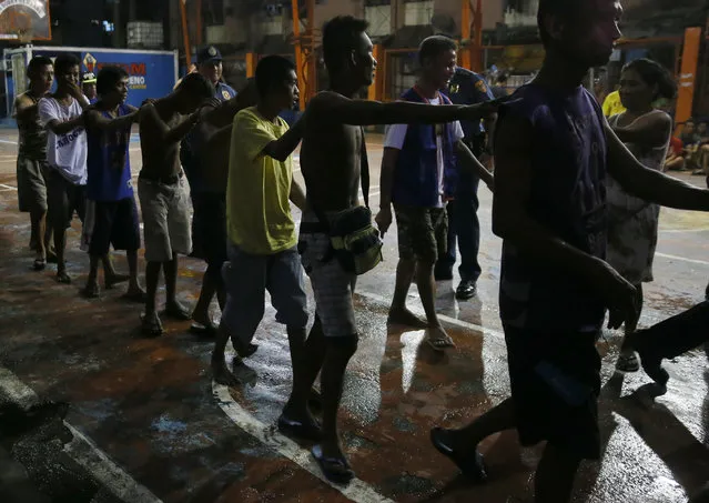 Police round up residents, during a police “One Time Big Time” operation in the continuing “War on Drugs” campaign of President Rodrigo Duterte at slum community of Tondo in Manila, Philippines late Friday, September 30, 2016. (Photo by Bullit Marquez/AP Photo)