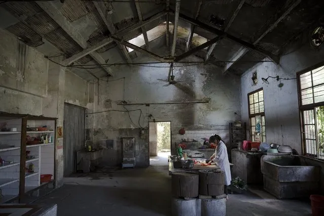A member of staff prepares lunch for her colleagues in a dilapidated service building at Yangjia Hospital in Wuyi County, Zhejiang Province, China October 19, 2015. (Photo by Damir Sagolj/Reuters)