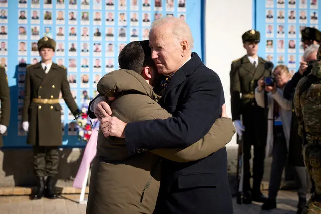 U.S. President Joe Biden embraces Ukraine's President Volodymyr Zelenskiy as they visit the Wall of Remembrance to pay tribute to killed Ukrainian soldiers, amid Russia's attack on Ukraine, in Kyiv, Ukraine on February 20, 2023. (Photo by Ukrainian Presidential Press Service/Handout via Reuters)