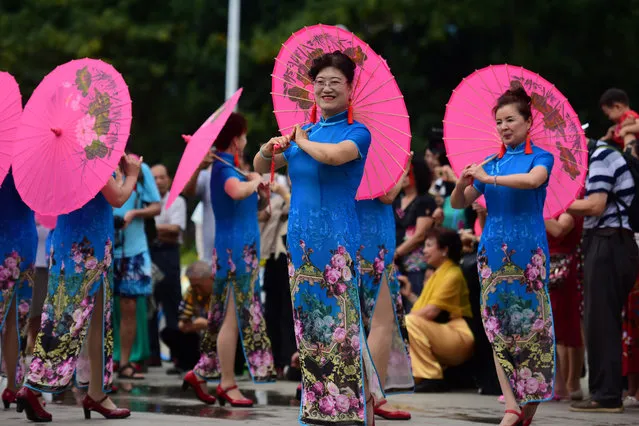 Women in cheongsams take part in a Cheongsam Show ahead of International Women's Day in Qionghai, Hainan province, China March 7, 2018. (Photo by Reuters/China Stringer Network)