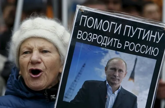 A woman holds a poster with a portrait of Russia's President Vladimir Putin during a demonstration on National Unity Day in Moscow, Russia November 4, 2015. Russia marks National Unity Day on November 4 to celebrate the defeat of Polish invaders in 1612. The sign reads, "Help Putin to revive Russia". (Photo by Sergei Karpukhin/Reuters)