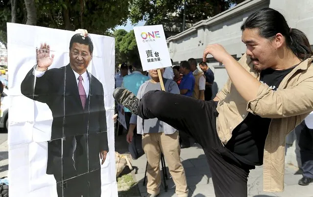 An activist kicks a portrait of Chinese President Xi Jinping during a protest against the upcoming meeting  between Taiwan's President Ma Ying-jeou and Chinese President Xi Jinping, in front of the Presidential Office in Taipei, Taiwan, November 5, 2015. Taiwan President Ma Ying-jeou said on Thursday his upcoming meeting with President Xi Jinping was about further normalising ties with China and had nothing to do with trying to revive his party's fortunes ahead of the island's elections in January. (Photo by Edward Lau/Reuters)