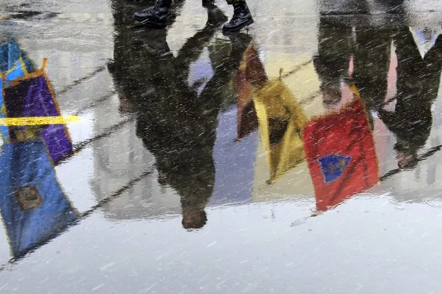 Soldiers are reflected in a puddle during a military parade during the celebrations for Romania's National Day in Bucharest December 1, 2014. (Photo by Radu Sigheti/Reuters)