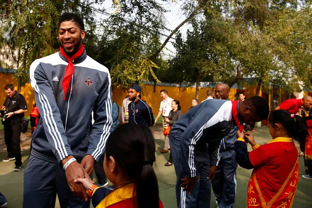 Basketball, NBA Global Games, New Orleans Pelicans training session ahead of preseason game against Houston Rockets, Beijing, China on October 11, 2016. New Orleans Pelicans player Anthony Davis shakes hands with a pupil as he arrives for a charity event at the Huangzhuang Migrant School. (Photo by Thomas Peter/Reuters)