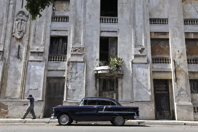 A 1955 Chevrolet is parked near an abandoned building in Havana, April 8, 2010. (Photo by Enrique De La Osa/Reuters)