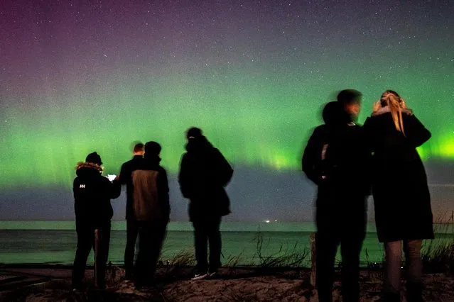 People observe the Northern Lights from Hornbaek beach, Sealand, Denmark on February 27, 2023. (Photo by Mads Claus Rasmussen/Ritzau Scanpix via Reuters)