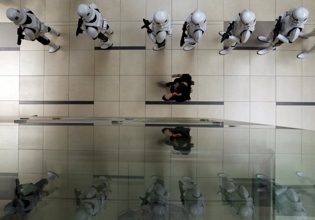 A coordinator checks on Stormtroopers lining up before they perform for members of the public at a life-sized "Star Wars" X-wing Fighter model on display at Singapore's Changi Airport November 12, 2015. (Photo by Edgar Su/Reuters)
