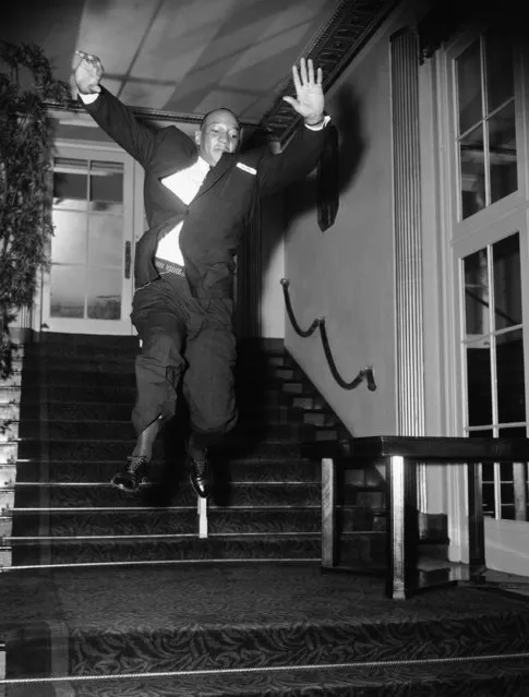Olympic broad jump champion Jesse Owens shows his old form for benefit of the photographer at the Waldorf-Astoria Hotel in New York City where he was honored on October 12, 1954, with other athletes at banquet for the all-time U.S. Olympic Games track and field team. In 1936 at Berlin, Germany, Jesse set records in winning the Olympic 100 and 200-meter runs and the broad jump. Banquet opened National Olympic Day drive to obtain public backing for U.S. team participation in the 1955 Pan American and 1956 Olympic games. (Photo mby mMarty Lederhandler/AP Photo)