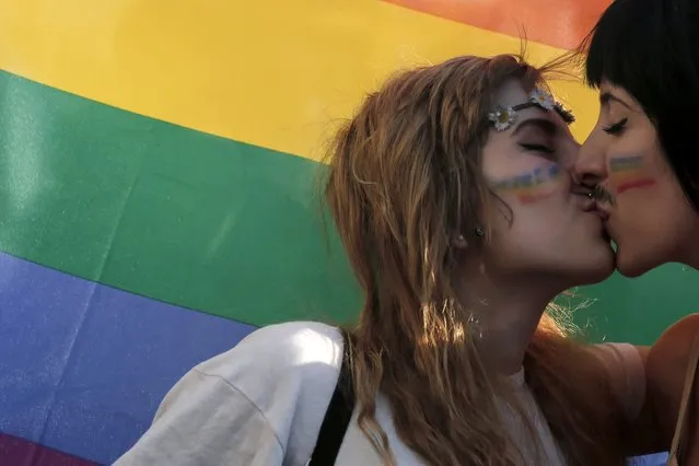 In this Saturday, June 14, 2014 file photo, two women kiss in front of a rainbow flag, the symbol of the gay rights movement, during the Gay Pride parade in central Athens, Greece. Ahead of May 21, general elections, Alexis Tsipras, head of the main left-wing opposition party, Syriza, promised on Tuesday, April 4, 2023 to legalize same-s*x marriage if he becomes the next prime minister. (Photo by Petros Giannakouris/AP Photo)